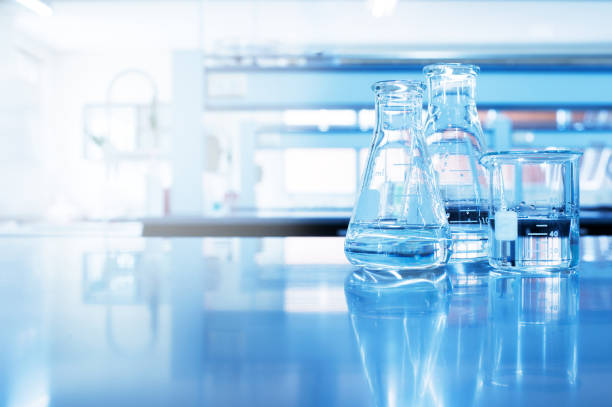 wasser in becher- und kolbenglas in chemie blau wissenschaftlicher laborhintergrund - laboratory glassware stock-fotos und bilder