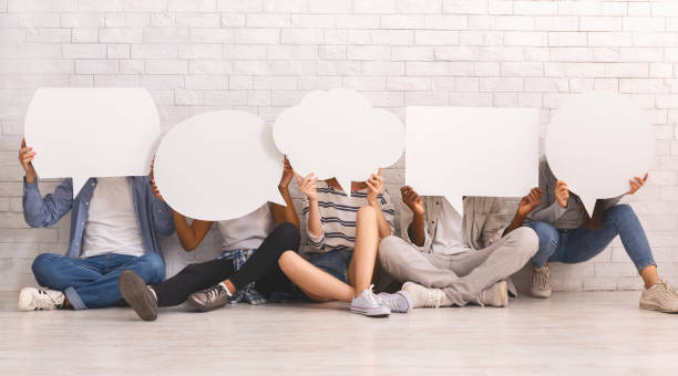 Students in casual clothes hiding behind speech bubbles