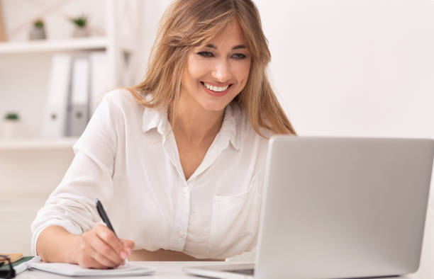 istock Businesswoman Taking Notes Working At Laptop Sitting At Workplace. 1199680157