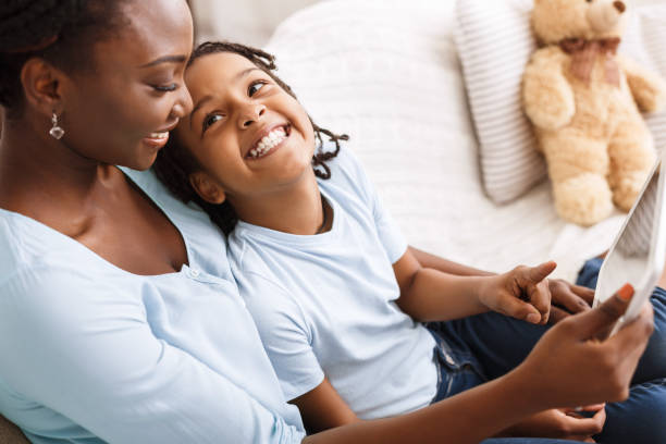 istock Black family using digital tablet at home 1199680293