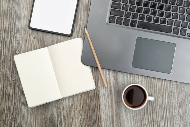 istock Workplace with opened blank notepad, laptop, tablet and a cup of coffee 1199681073