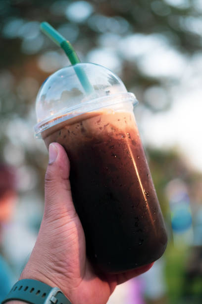 istock Black coffee with ice in plastic glass in hand. Thai called Oliang 1199682580