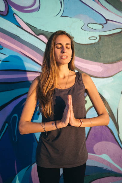 istock Yoga namaste pose against  colorful wall 1199683574
