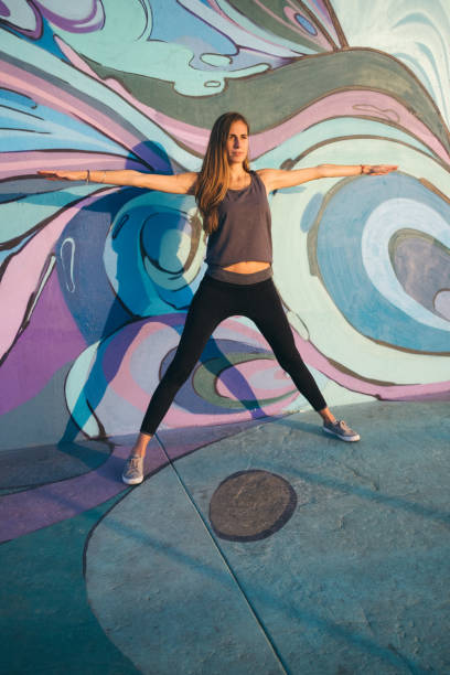 istock Yoga Warrior Three pose against  colorful wall 1199683704
