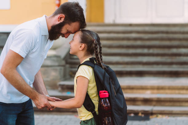istock Father leads daughter on first day of school 1199684346