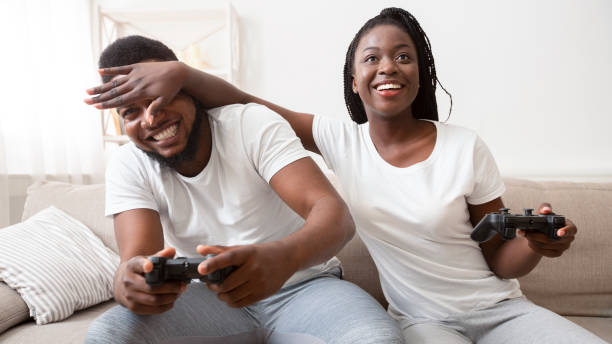 istock Millennial couple playing videogames sitting on couch at home. 1199685109