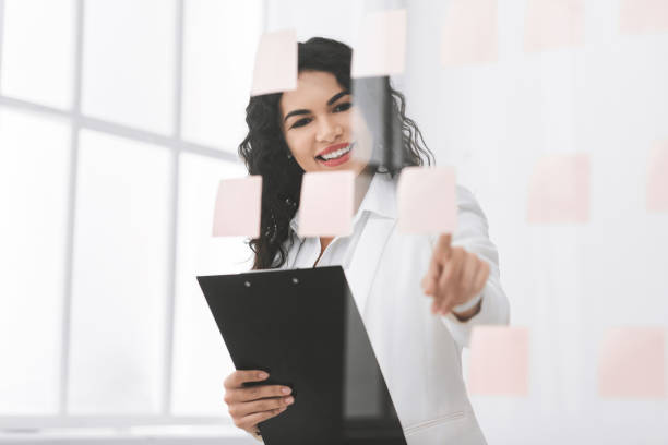 istock Latin manager girl looking at notes on window 1199685160