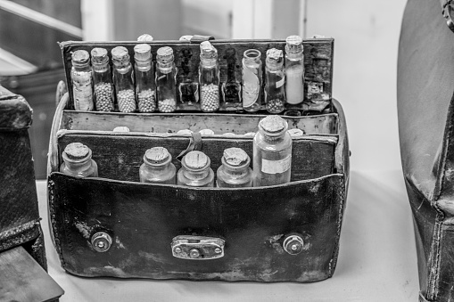 Vintage Medicine Bag. Black and white leather doctor bag with several glass bottles of herbs, tinctures, and home