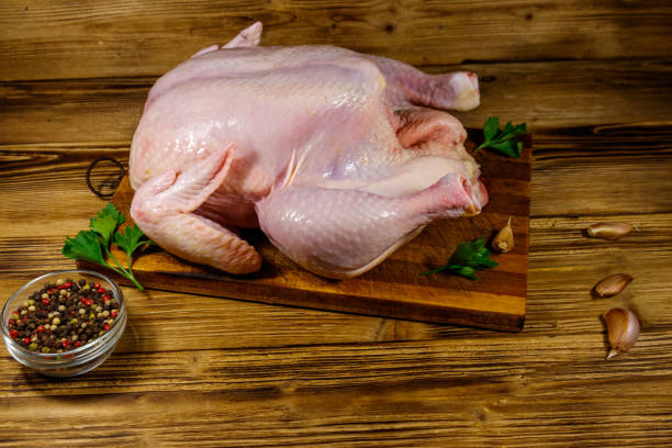 istock Raw whole chicken with spices on a wooden table 1199686229