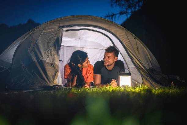 istock Young Campers Lying Side by Side on Tent Porch and Talking 1199686288