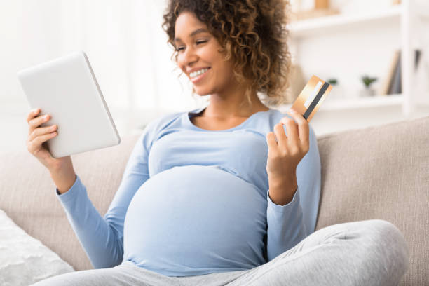 istock African-american expectant woman purchasing goods on tablet 1199686314
