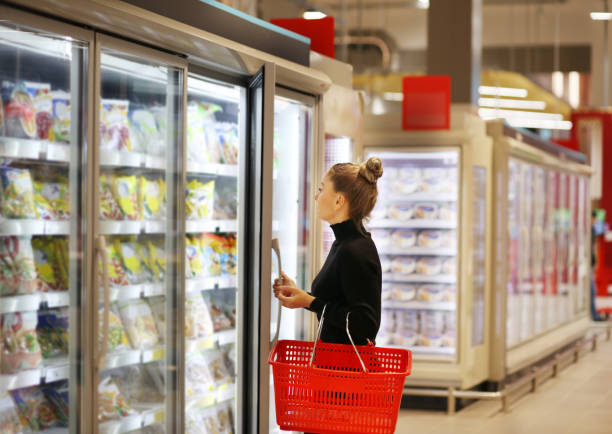 ��スーパーマーケットの冷凍庫から冷凍食品を選ぶ女性 - 冷凍食品 ストックフォトと画像