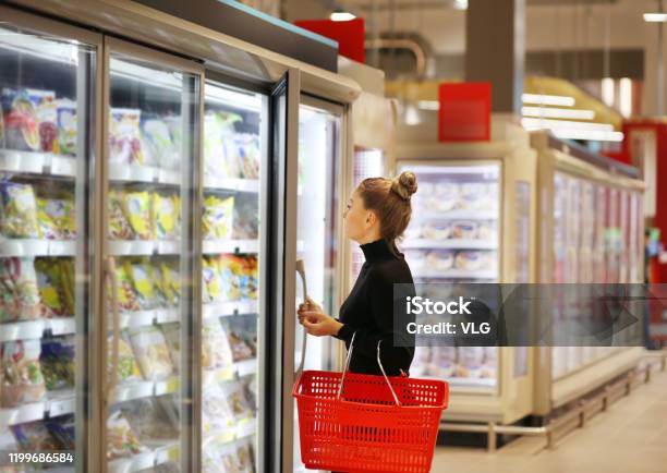 Woman Choosing Frozen Food From A Supermarket Freezer Stock Photo - Download Image Now