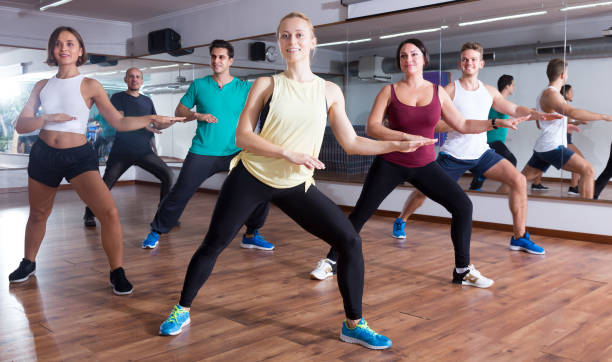 Cheerful positive people learning zumba steps Cheerful positive people learning zumba steps in dance hall curtseying stock pictures, royalty-free photos & images