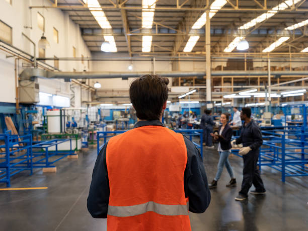 istock Back view of supervisor entering a water pump factory 1199687562