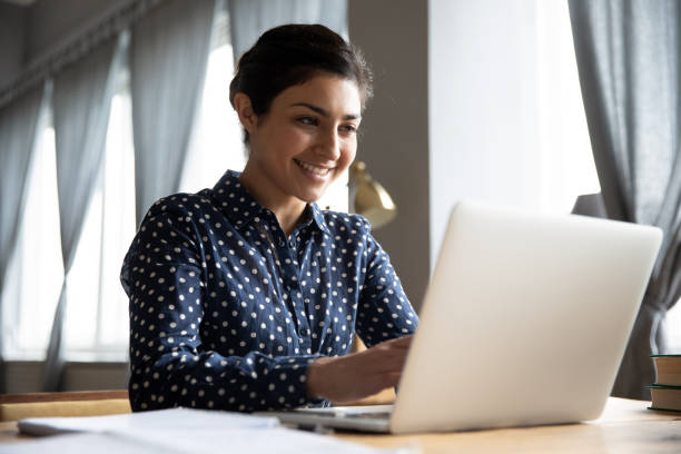 a estudante indiana de sorriso que dá digitação no portátil na tabela - asian ethnicity women businesswoman people - fotografias e filmes do acervo