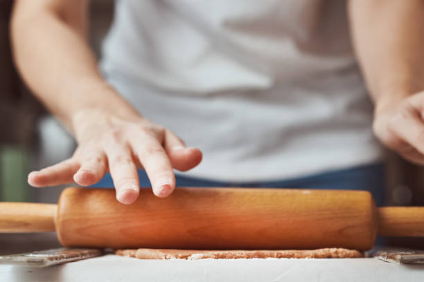 istock Female hands rolling dough on the table, closeup. Woman making dough for baking in kitchen 1199687896