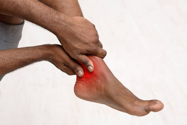 cropped of black man rubbing his ankle - reflexology massaging recovery sport imagens e fotografias de stock