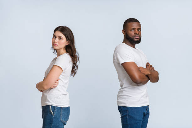 istock Upset interracial couple standing back to back with folded arms 1199689278