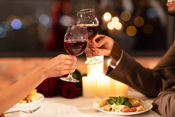 couples's hands clinking glasses of red wine dating in restaurant couples's hands clinking glasses of red wine dating in restaurant couples's hands clinking glasses of red wine dating in restaurant couples' - anniversary couple rose black photos et images de collection