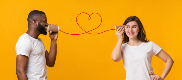 istock Loving black guy telling romantic words to girlfriend through tin phone 1199691081