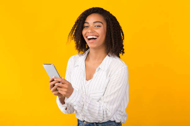 istock Happy black woman using cell phone looking at camera 1199691320