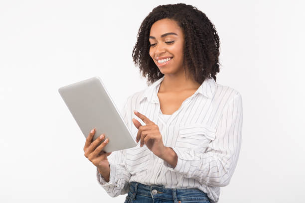 istock Smiling afro woman reading email on digital tablet 1199692595