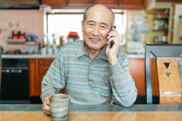 istock Portrait of senior man while talking on smart phone happily 1199692765