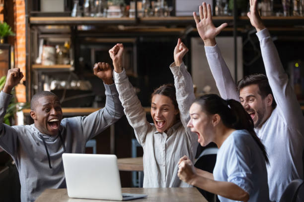 istock Euphoric diverse friends celebrating victory watching online game on laptop 1199696828