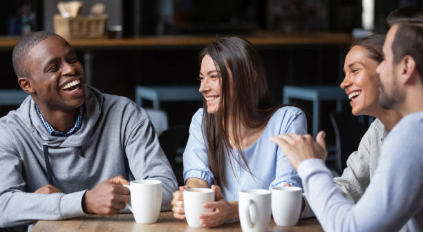 wielorasowe przyjaciele dziewczyny i faceci bawiąc się śmiejąc się pijąc kawę - friendship cafe social gathering talking zdjęcia i obrazy z banku zdjęć