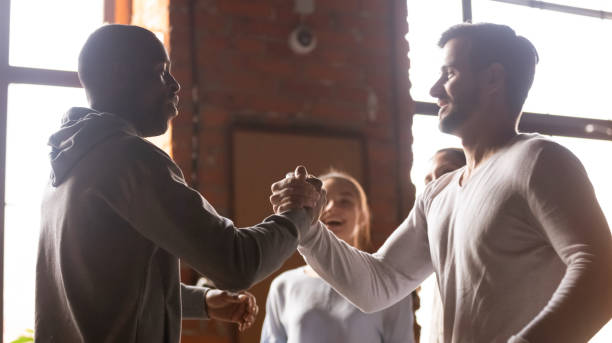 istock Happy diverse male buddies greeting at group meeting 1199696873