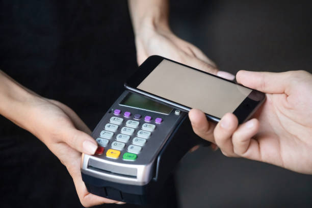 istock Male customer make payment holding phone above nfc terminal, closeup 1199696874