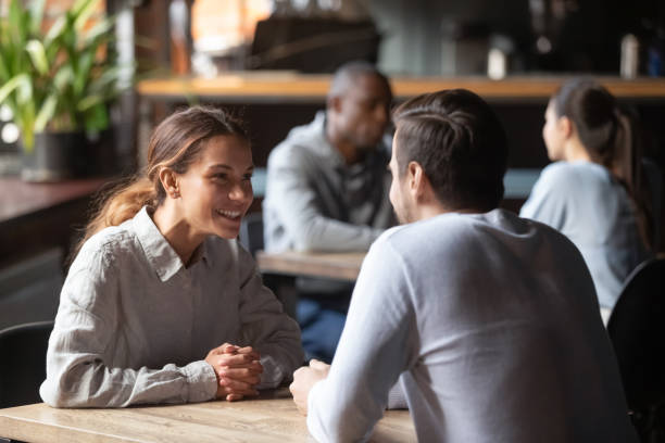 istock Happy young couple smiling chatting sitting at cafe table 1199696878