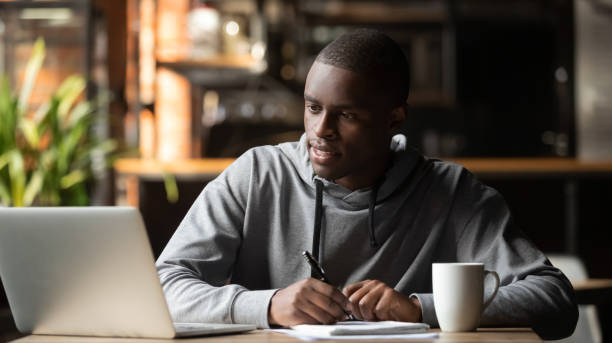 istock Focused young man studying with laptop make notes in cafe 1199697109