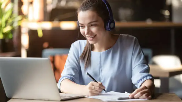 Photo of Smiling girl wear wireless headphone study online with skype teacher