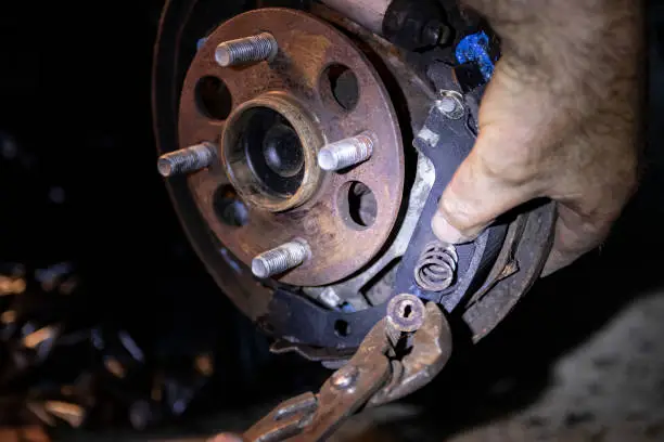 Photo of Mechanic hands fixing brakes