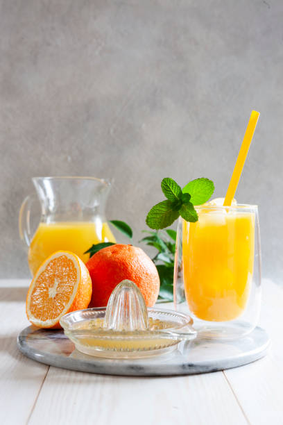 jugo de naranja natural recién exprimido con hielo y menta en un vaso - orange portion fruit citrus fruit fotografías e imágenes de stock