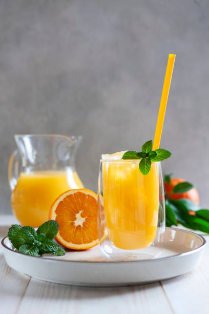 natural freshly squeezed orange juice with ice and mint in a glass - lemon fruit portion citrus fruit imagens e fotografias de stock