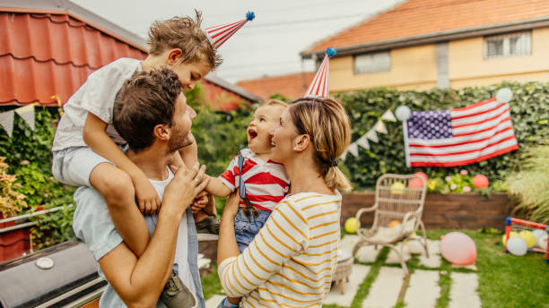 Happy family celebrating Fourth of July Photo of a happy family celebrating Fourth of July in their yard barbecue social gathering photos stock pictures, royalty-free photos & images