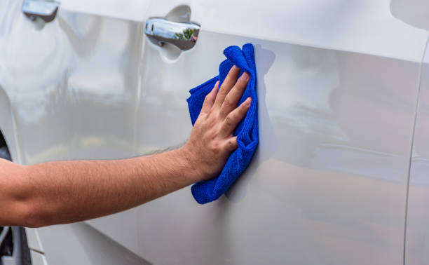 istock Hand holding a microfiber cloth wiping the car 1199704646