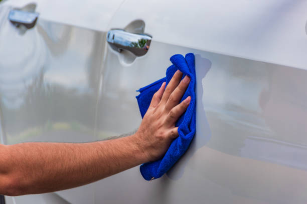 istock Hand holding a microfiber cloth wiping the car 1199704661