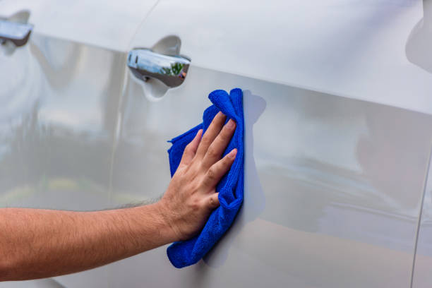 istock Hand holding a microfiber cloth wiping the car 1199704746