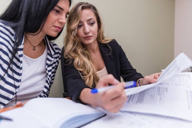 istock Women sharing office and revising paperwork 1199705314