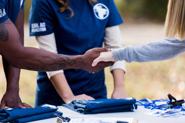 istock Unrecogniazble man at registration table shakes hands with volunteer 1199705908