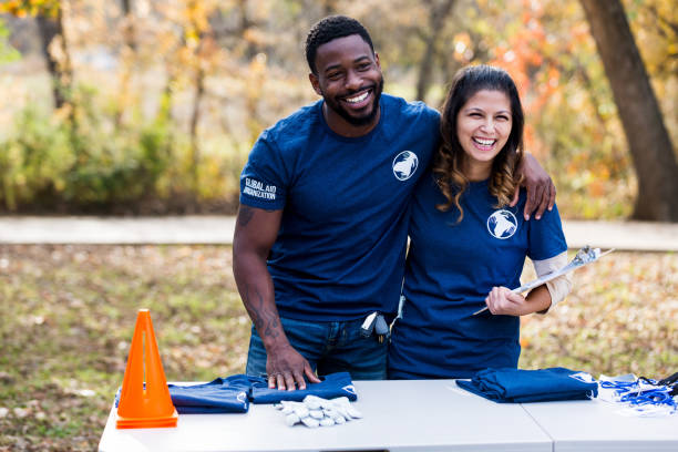 istock Diverse couple enjoys working at cleanup event registration table 1199705914