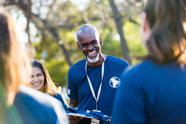 istock Mature man smiles and laughs with diverse volutneer group 1199705929