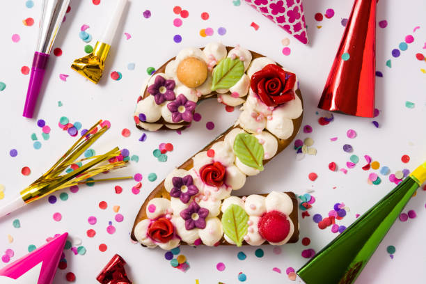 istock Number two cake decorated with flowers, macarons and confetti 1199706113