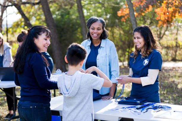 istock Mother smiles while son gestures and talks to registration volunteers 1199706217