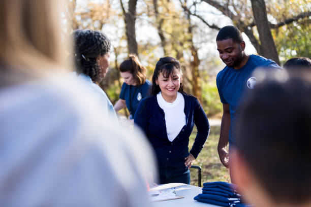 istock Park cleanup volunteers stand at table to solve problem 1199706230