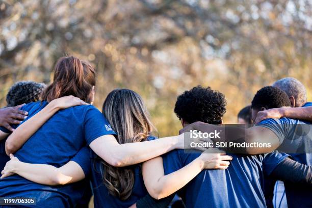 Friends Linking Arms In Unity Stock Photo - Download Image Now - Community, Volunteer, Charity and Relief Work